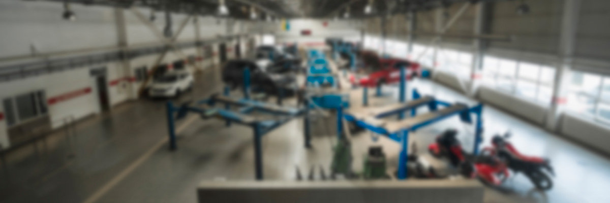 Overview of an automotive shop with large windows and shiny, epoxy flooring.